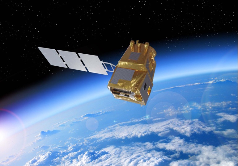 The image is an artist’s impression of an LSTM (Land Surface Temperature Monitoring) satellite. The satellite features a box-shaped main body covered in golden insulating material, with solar panels extending from one side. It is depicted orbiting above the Earth, with the planet's cloud-covered surface visible below. The satellite is designed to monitor land surface temperatures. The background shows the dark expanse of space dotted with stars. This satellite image is credited to Airbus.